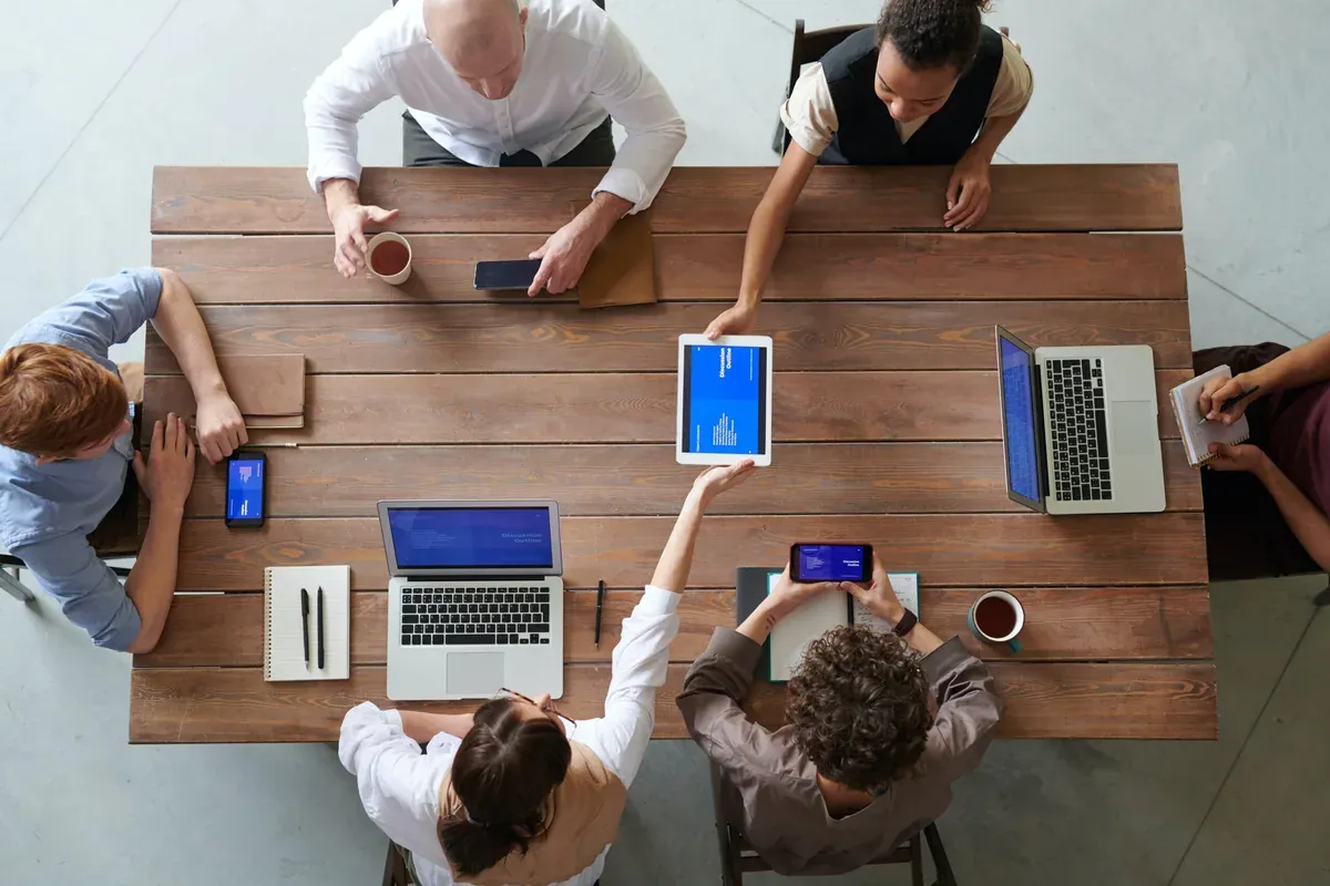 Team working together at a table with laptops and notes